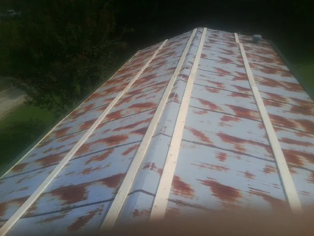 Rusted metal roof panels with new wood purlins before replacement — Storm Damage Roof Repair in Oakwood by Roofing Brothers