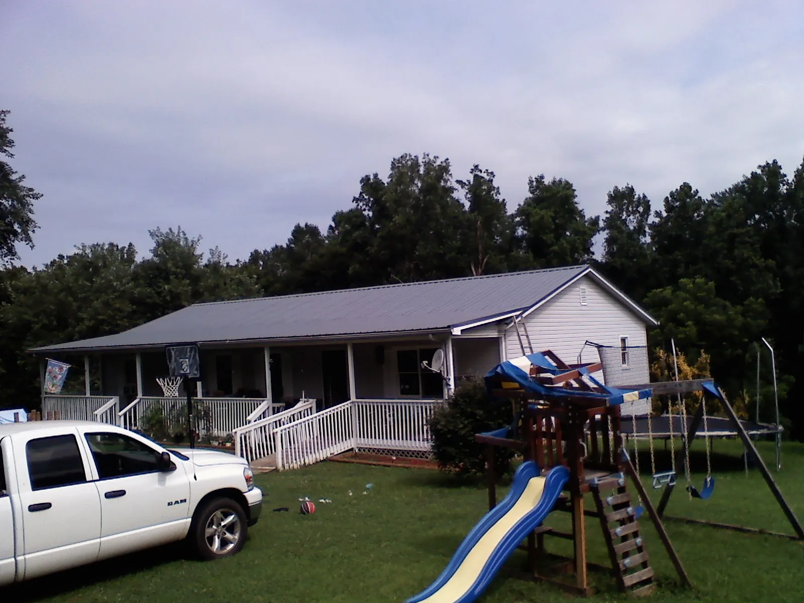 Dark metal roof on a country home with a full length front porch in Oakwood