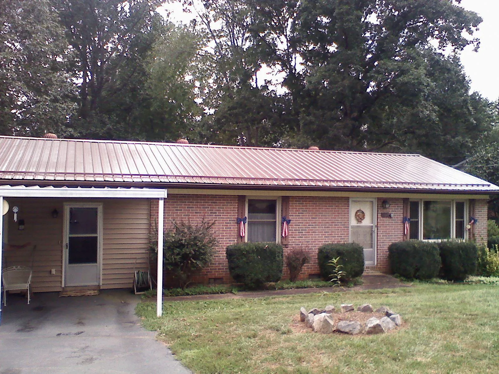 Bronze metal roof and carport on a brick ranch home — Roof Repair work by our crew in Oakwood