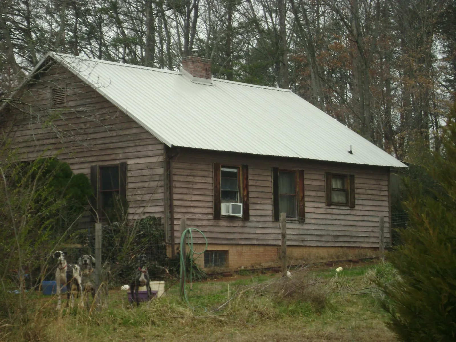 White metal roof on an old wood sided farmhouse, from a Metal Roof Installation job in Oakwood